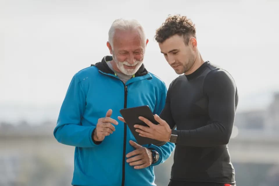 Un coach montre ses progrès à son élève sur une tablette